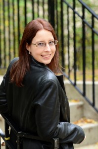 Photo of Carolyn Hoessler leaning on railing looking over shoulder by Heather Fritz